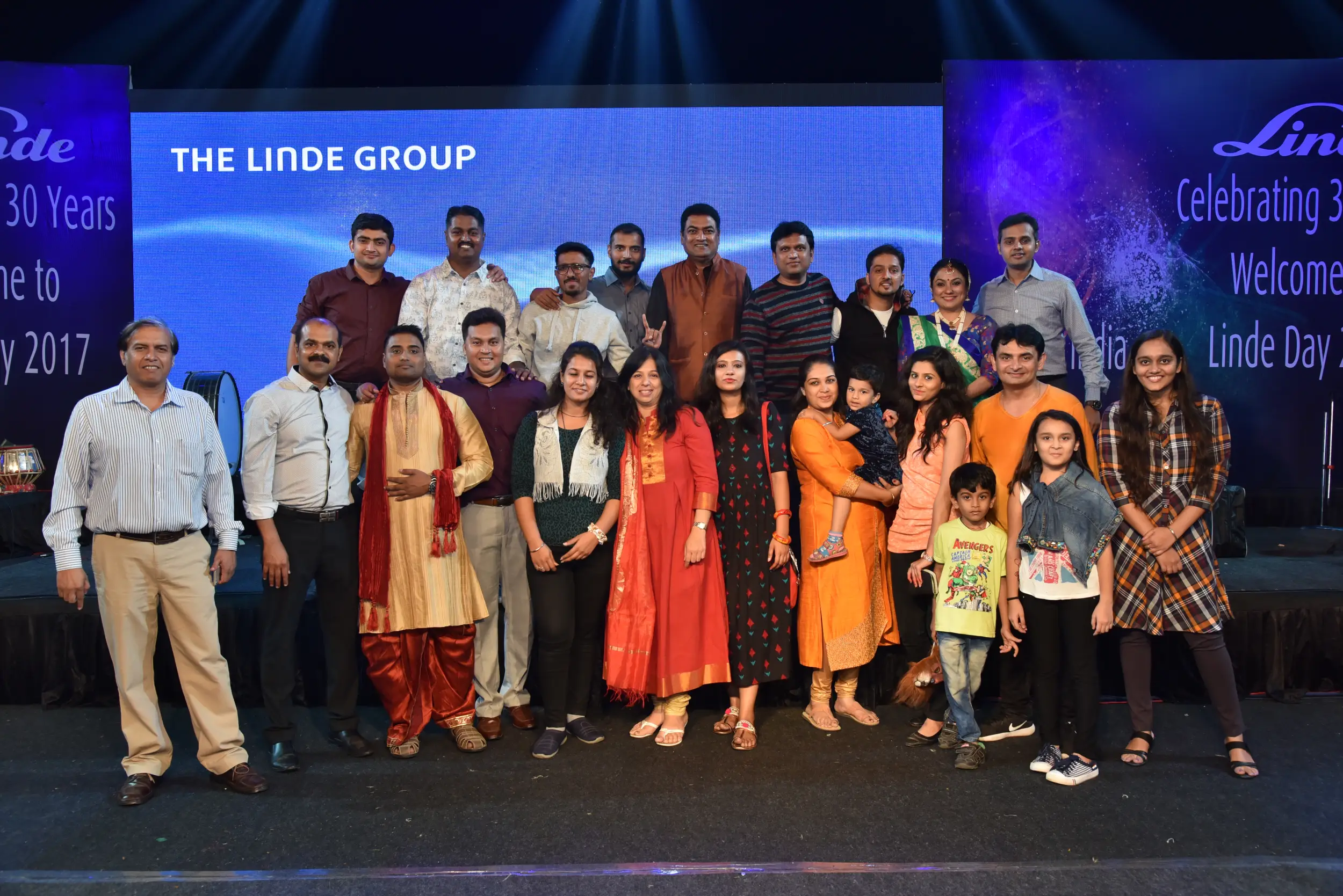 Man and woman speaking on stage at night with blue lighting